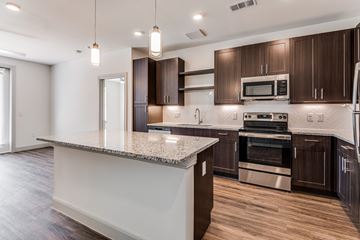Dallas apartment for rent - A modern kitchen with dark wood cabinets and stainless steel appliances.