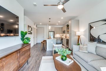 Dallas apartment for rent - A modern living room with a wooden coffee table and a grey sofa.