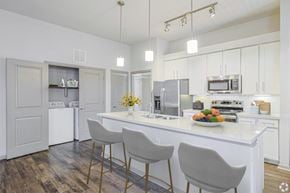 Austin apartment for rent - A kitchen with a white countertop and grey chairsat Radius on Grove, Austin