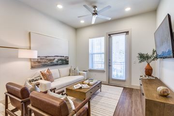 Fort Worth apartment for rent - A living room with a brown leather chair and a white sofa.