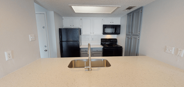 Austin apartment for rent - a kitchen with a sink and a black refrigerator