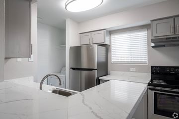 Austin apartment for rent - A kitchen with a white counter top and stainless steel appliances.