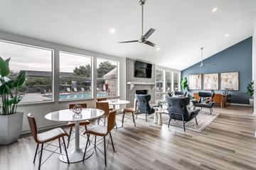 San Antonio apartment for rent - A modern dining room with a table set for six and a television mounted on the wall.