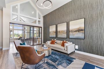 Saginaw apartment for rent - A modern living room with a white couch and a brown chair.