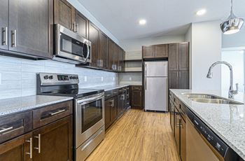 A kitchen with wooden cabinets and stainless steel appliances