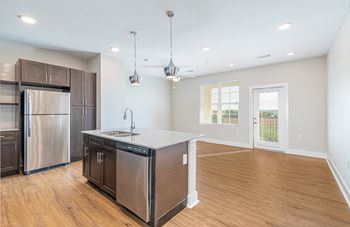 A kitchen with a large island and a stainless steel refrigerator