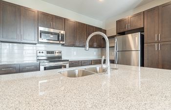 A kitchen with stainless steel appliances and marble counter tops