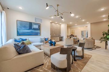 Boerne apartment for rent - A living room with a white sofa, a coffee table, and a painting on the wall.