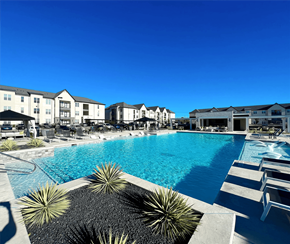 San Marcos apartment for rent - a large swimming pool with buildings in the background at The Fitzroy San Marcos, San Marcos, Texas