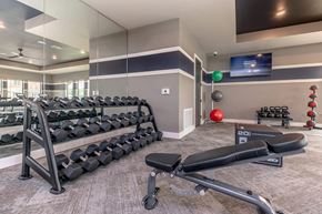 San Antonio apartment for rent - Weight training area with dumbbells and workout bench at Sienna at Westover Hills Apartments, San Antonio, 78253