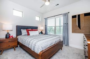 San Antonio apartment for rent - Modern bedroom with upholstered headboard and ceiling fan at Sienna at Westover Hills Apartments, San Antonio