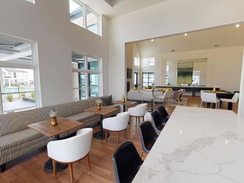 A large living room with tables and chairs and a counter
