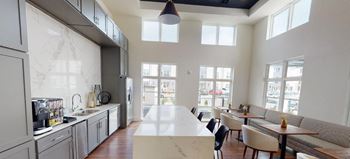 The kitchen and dining area of an open floor plan with a large white counter top
