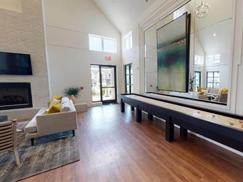 A large living room with a fireplace and a large mirror