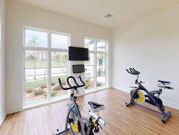 A home gym with exercise bikes and a tv