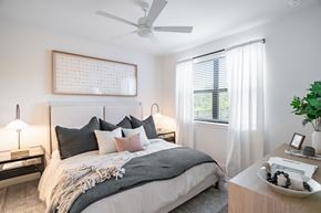 Austin apartment for rent - Cozy bedroom with neutral tones and layered bedding at Hangar at Bergstrom Apartments, Texas