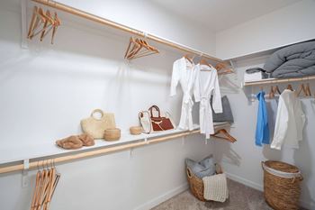 Walk-in closet with wooden shelving and hanging rods