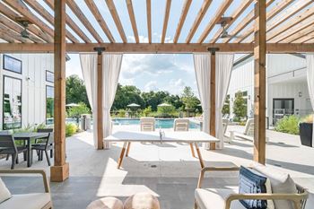 Outdoor pergola dining area with pool views