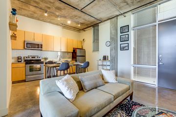 San Antonio apartment for rent - A living room with a couch and a kitchen area in the background.