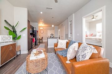 San Antonio apartment for rent - A living room with a brown couch and a wicker table.