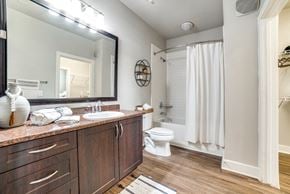 San Antonio apartment for rent - a bathroom with a large mirror and a white shower curtain at The Landings at Brooks City-Base, Texas, 78235