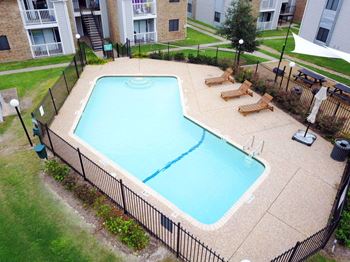 An aerial view of a swimming pool in front of an apartment building