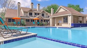 Houston apartment for rent - a swimming pool with chairs and a house in the background at Tranquility Grove, Texas 77090