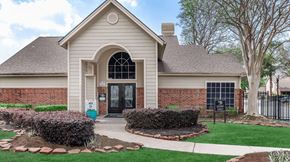 Houston apartment for rent - the front of a house with a driveway and lawn at Tranquility Grove, Houston