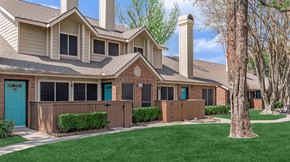 Houston apartment for rent - a house with a blue door and green grass at Tranquility Grove, Houston, Texas