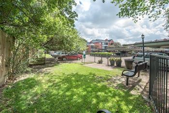 Fenced courtyard with green lawn and park bench