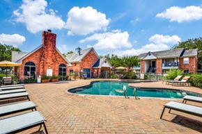 Houston apartment for rent - Pool area with brick clubhouse and lounge chairs at Monarch Medical Center Apartments, Texas, 77054