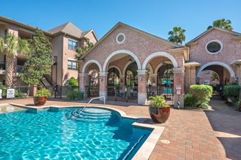 Poolside pavilion with arched columns and paver deck