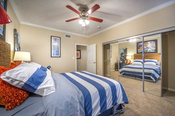 Bedroom with striped bedding and mirrored closet doors