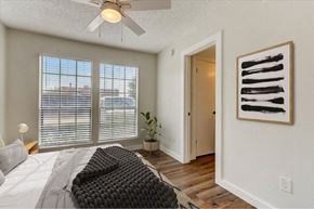 Garland apartment for rent - Bedroom with wood flooring and ceiling fan at The Courtyard Apartments, Garland, TX 75044