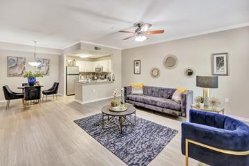 Haltom City apartment for rent - A living room with a grey sofa and a blue armchair.