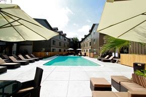 Austin apartment for rent - A pool surrounded by sun loungers and umbrellas.
