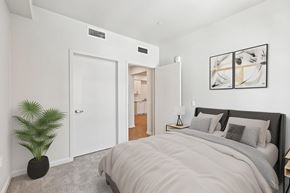 La Mesa apartment for rent - A bedroom with a large bed and a potted plant.