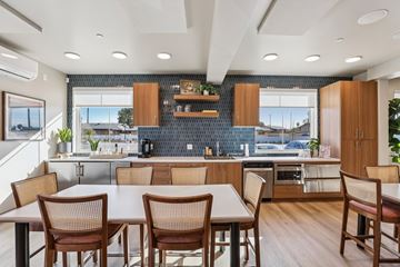 Orange apartment for rent - A modern kitchen with a dining table and chairs.