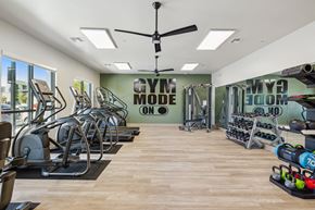 Rocklin apartment for rent - a gym with cardio machines and weights on the floor and a wall with a quote
