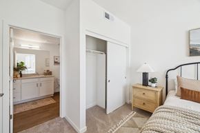 Rocklin apartment for rent - a bedroom with a bed and a bathroom with a mirror
