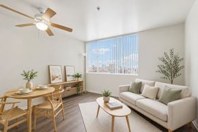 Huntington Park apartment for rent - A living room with a couch, table, chairs, and a ceiling fan.