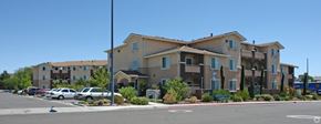 Spark apartment for rent - Apartment complex with a parking lot in front.