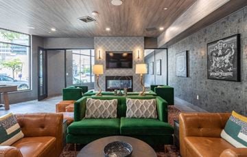 New Haven apartment for rent - A living room with a green couch and brown leather chairs.