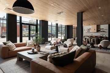 Hartford apartment for rent - A modern living room with brown leather couches and a wooden ceiling.