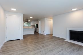 Tacoma apartment for rent - A white interior with a fireplace and a kitchen in the background.
