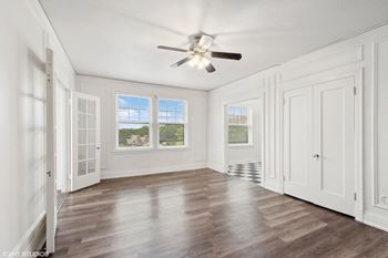 A living room with white walls and a ceiling fan