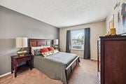Columbus apartment for rent - A bedroom with a large bed and a window overlooking a balcony.