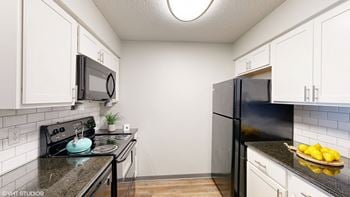 A kitchen with black appliances and white cabinets