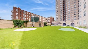 A large grassy area with a golf course in front of a building
