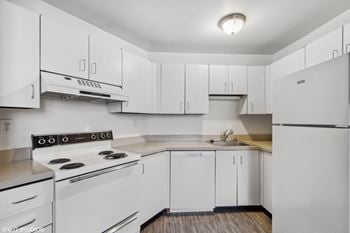 A white kitchen with white appliances and white cabinets